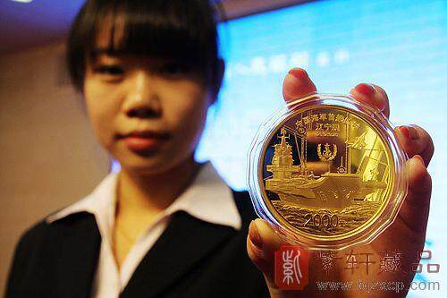 「工作人员向媒体展示中国人民解放军海军航母辽宁舰5盎司金质纪念币」